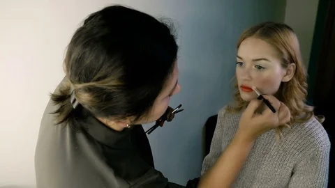 Hand of make-up master, painting lips of young beautiful model. Makeup in 스톡 동영상 82119528