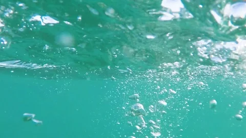 Hand makes air bubbles and shiny highlights in the water Stock Footage 84549746