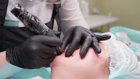 Hand makes permanent makeup lips procedure applying pigment makeup on lips with Video stock 152126304