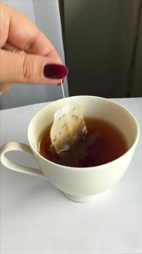 A hand makes tea bags in a white mug and on the kitchen table Vídeo Stock 311975230