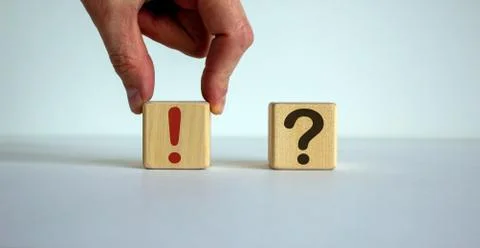 Hand making a choice between two cubes with exclamation mark and question mar Stock Photos