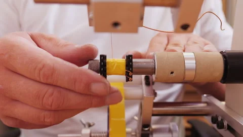 Hand making electronic component using coil winding machine - close up Video stock 139516039