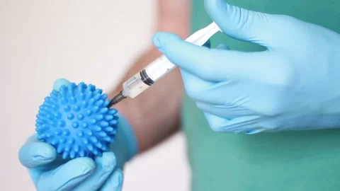 Hand making injection into blue ball 動画素材 157355462