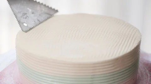 Hand making pattern on butter cream cake, slow motion. Stock Footage 98490084