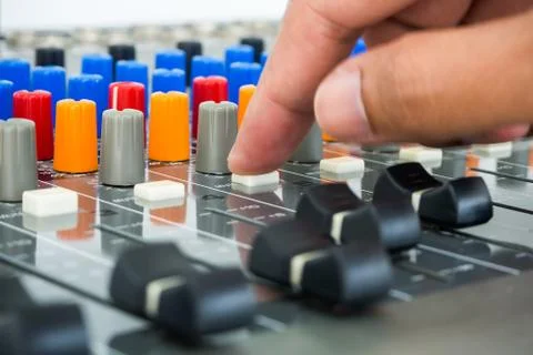 Hand making push button on an audio soundboard Stock-Fotos