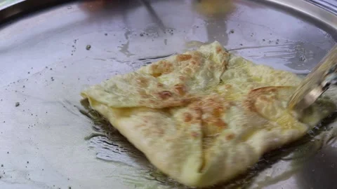 Hand making roti from flour and cheese in metal pan and hot oil Stock Footage 141306073