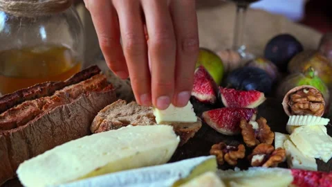 Hand is making snack for wine from slice of bread, cheese and fig 스톡 동영상 145404125