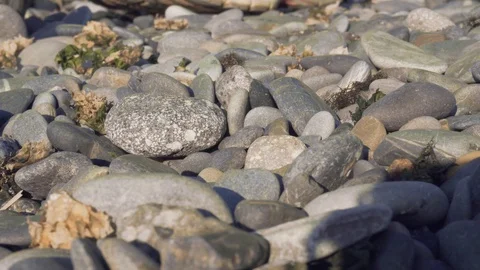 Hand making stone tower on sea beach. Building a stack of stones on the beach. Video stock 129775696