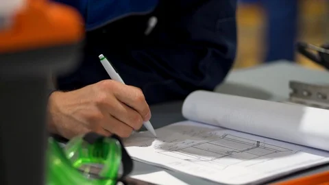 Hand of male builder writes, draws, makes notes in construction project on table Stock Footage 126357913