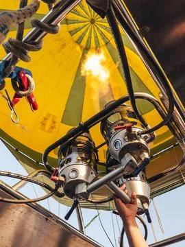 Hand of a man adding hot air to the inside of a balloon. Stock Photos
