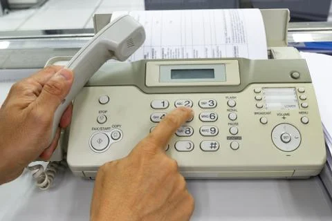 Hand man are using a fax machine in the office Photos