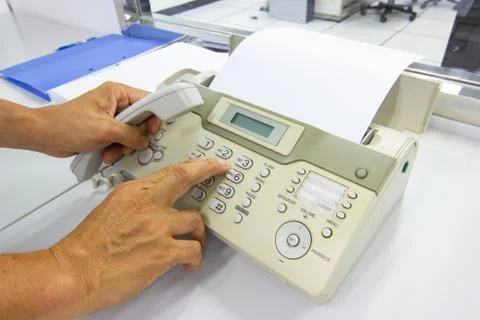 Hand man are using a fax machine in the office Business concept Stock Photos
