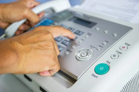 Hand man are using a fax machine in the office Photos