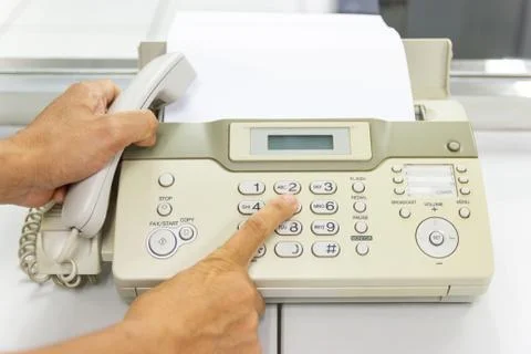 Hand man are using a fax machine in the office Stock Photos