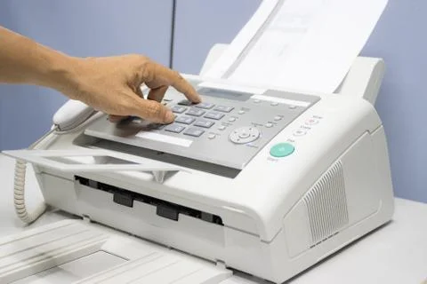 Hand man are using a fax machine in the office Photos