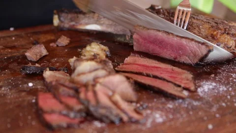 Hand of man chef cutting delicious juicy meat on barbecue board. Stock Footage 128001527