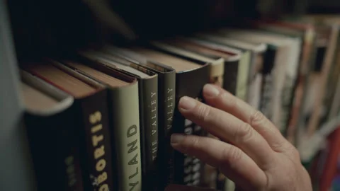 Hand of Man Choosing and Taking Book from Shelf in Public Library Video stock 293633510