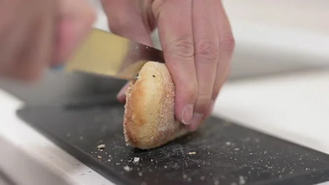Hand of a man cutting a frozen bread in half to prepare a delicious breakfast Video stock 201166758