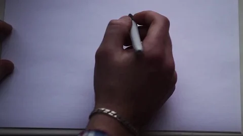 The hand of the man draws a smiley face on a white sheet of paper Stock Footage 70899669