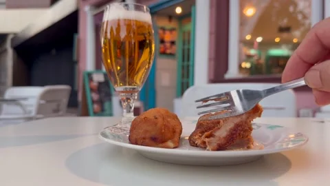 Hand of a Man Eating Handmade Ham Croquettes and Drinking a Beer. Typical Stock Footage 337737107