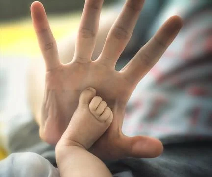 The hand of a man gives five to a small child's leg. selective focus Stock Photos