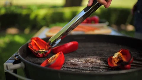Hand of a man grilling bell peppers. Stockbeeldmateriaal 88406647