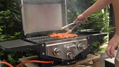 Hand of man grilling some meat on grill. Stock Footage 151676503
