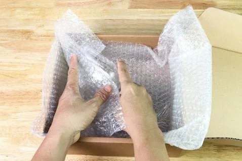 Hand of man hold bubble wrap cover glass for protection product cracked 스톡 사진