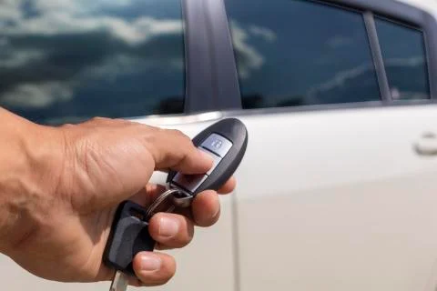 Hand man hold button unlock on the car remote control for unlock door white c Stock Photos