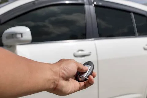Hand man hold button unlock on the car remote control for unlock door white c Stock Photos