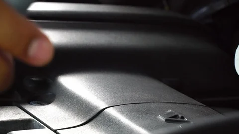 A hand of a man holding engine oil container pouring engine oil into an engine Vidéo 108644297