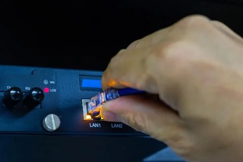 Hand of man holding The network cables to connect SFP module port Stock Photos