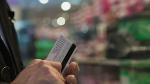 Hand of a man holding plastic card in front of a shop window Stock-Footage 43483550