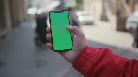Hand of man holding vertical smartphone doing swiping and typing gestures on Stock Footage 117429344