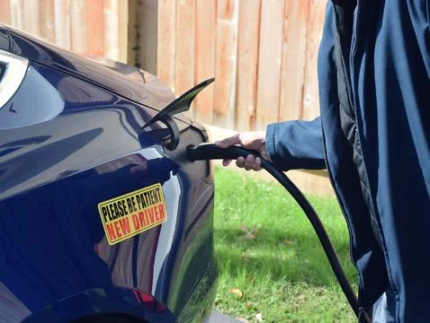 Hand of a man inserting the Tesla Charging cable Stockfoto's