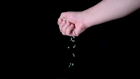 Hand of a man making rice grains, with black background, in slow motion. Stock Footage 133323969