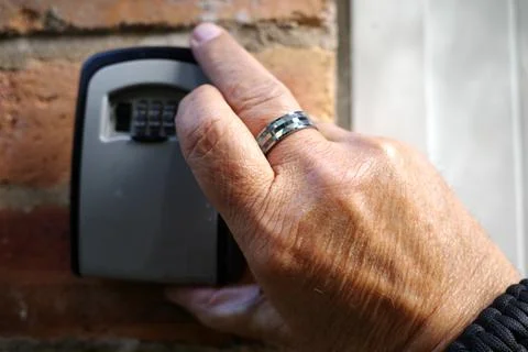 The hand of a man opening a keybox Foto stock