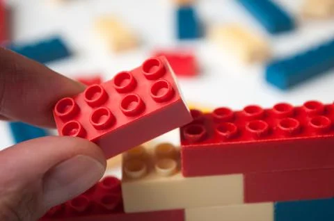 Hand of man playing with plastic bricks construction Stock Photos