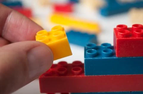 Hand of man playing with plastic bricks construction Stock Photos