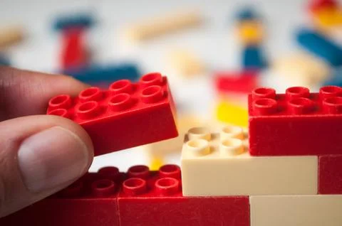 Hand of man playing with plastic bricks construction 스톡 사진