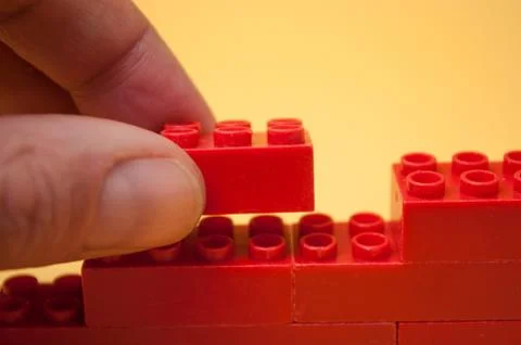 Hand of man playing with plastic bricks construction 写真素材