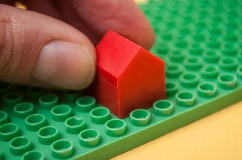 Hand of man playing with plastic bricks construction on background Stock Photos