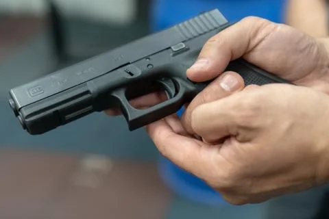 A hand of man practicing firing using a Glock gun model at the shooting range Fotos Stock