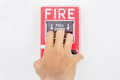 Hand of man pulling fire alarm switch on the white wall as background for e.. Stock Photos