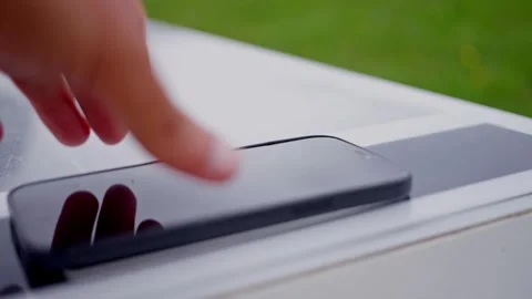Hand of man puts smartphone on mobile station. Smart bench with phone charger Stock Footage 253184326
