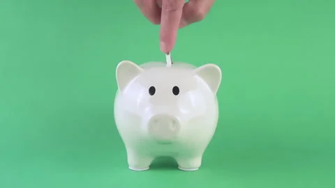 Hand of a man putting paper banknote into white piggy bank on the green scre Video stock 308399586
