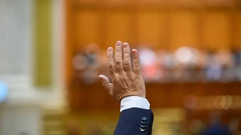 Hand of a man raised in the air during a voting procedure Stockbeeldmateriaal 84415977