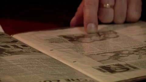 Hand of a Man Reading the Page of an Old Newspaper. Close Up.   Stock Footage 239568761