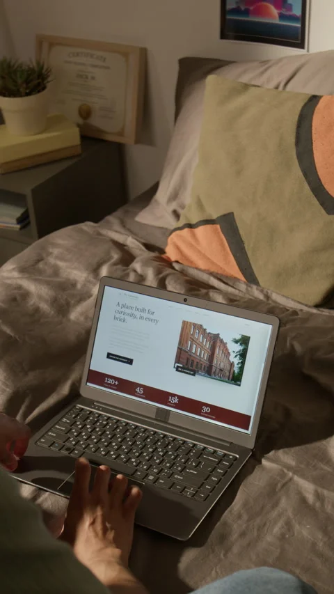 Hand of Man Researching College Courses on Laptop Computer in Bed Stock Footage 338106522