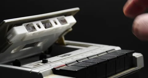 Hand of a man retrieving an audio cassette from a recorder Stock Footage 169684049
